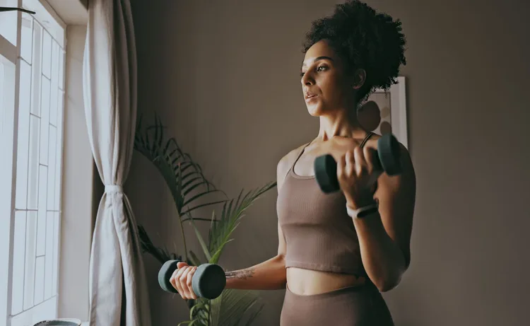 woman doing dumbbell bicep workout at home